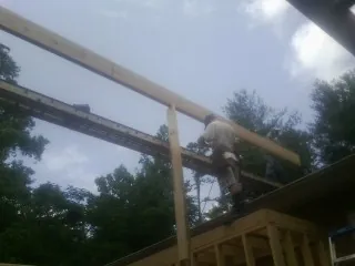 Carpenter setting a ridge beam over a new addition frame — Ice Dam Removal by Roofing Brothers in Luna Pier