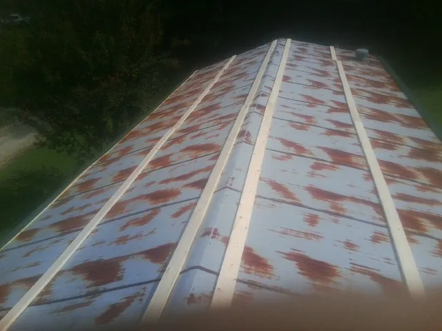 Rusted metal roof panels with new wood purlins before replacement — Storm Damage Roof Repair in Luna Pier by Roofing Brothers
