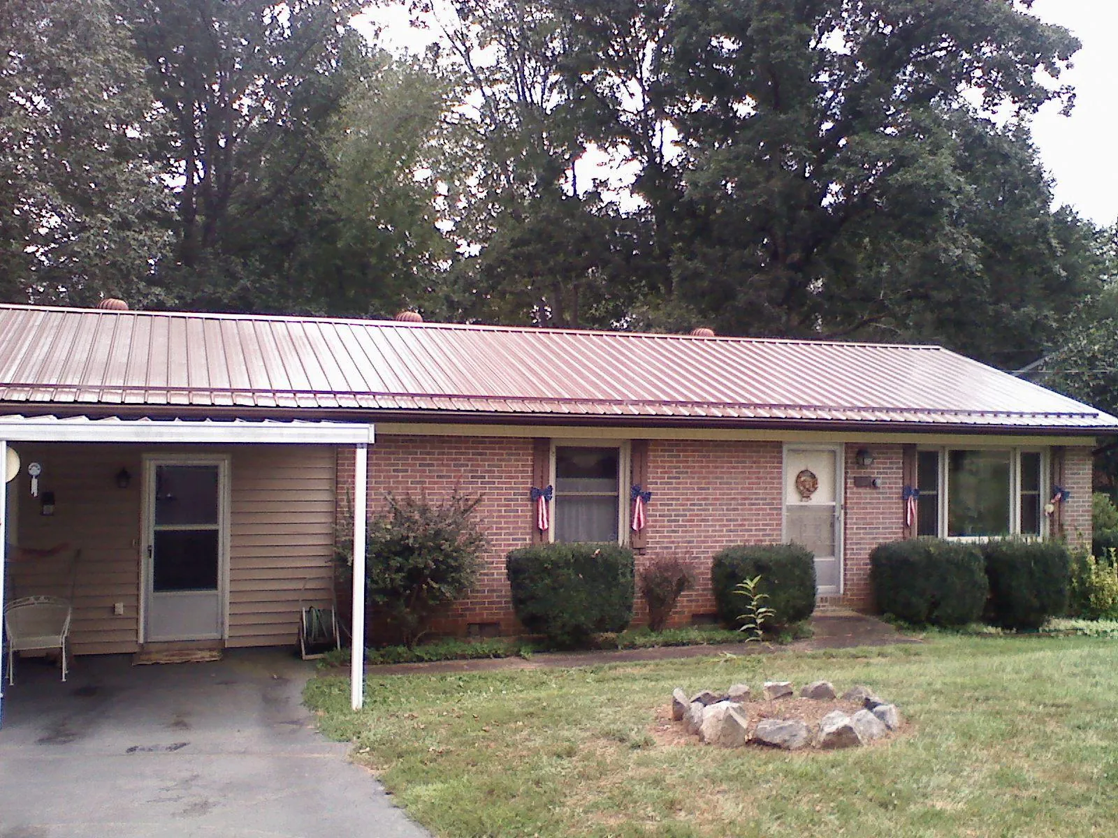 Bronze metal roof and carport on a brick ranch home — Roof Repair work by our crew in Luna Pier